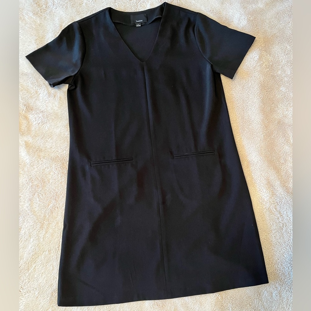 Black sheath with pockets. 100% polyester. V neck.